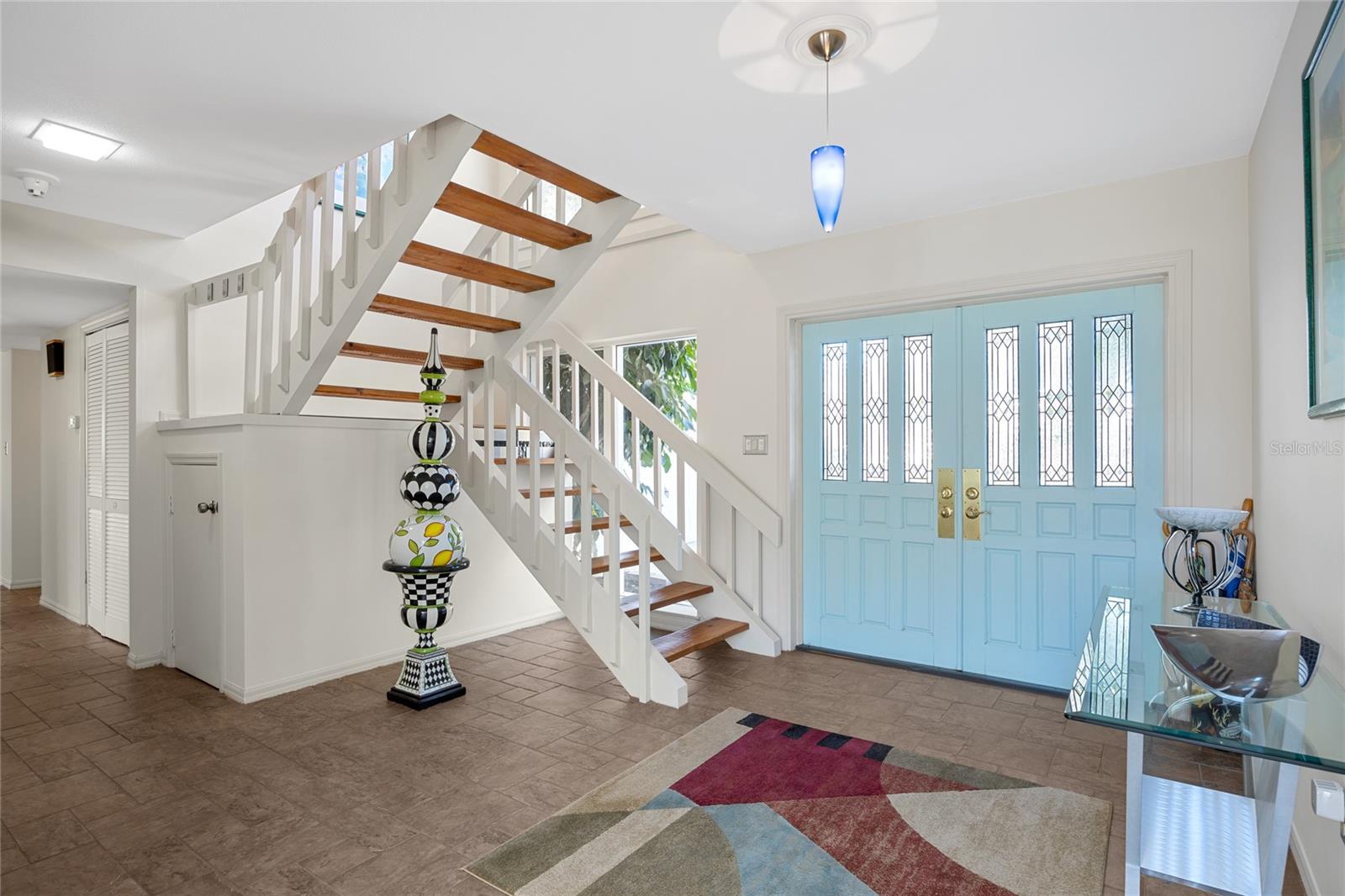 Grand double front entry doors lead to a stunning foyer, showcasing an open staircase and abundant closet and storage space