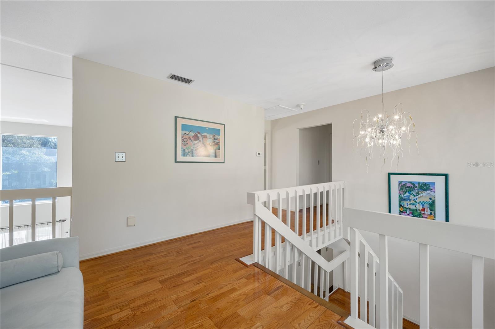 The loft area at the top of the staircase overlooks the expansive family room, creating an open and airy atmosphere