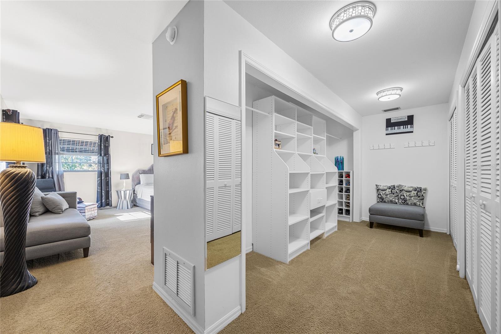 The expansive walk-in closet is equipped with built-in shelving, offering ample storage and making it easy to organize all of your belongings