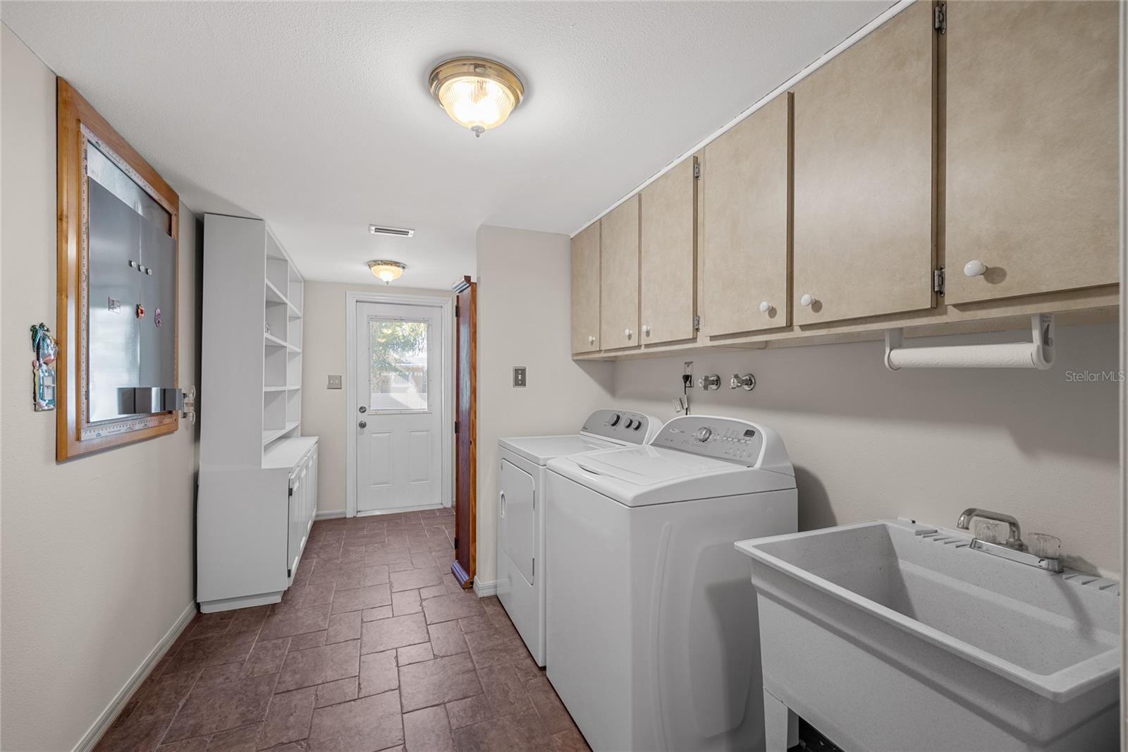 The laundry room is incredibly spacious, featuring additional storage and a convenient laundry sink, making chores a breeze.