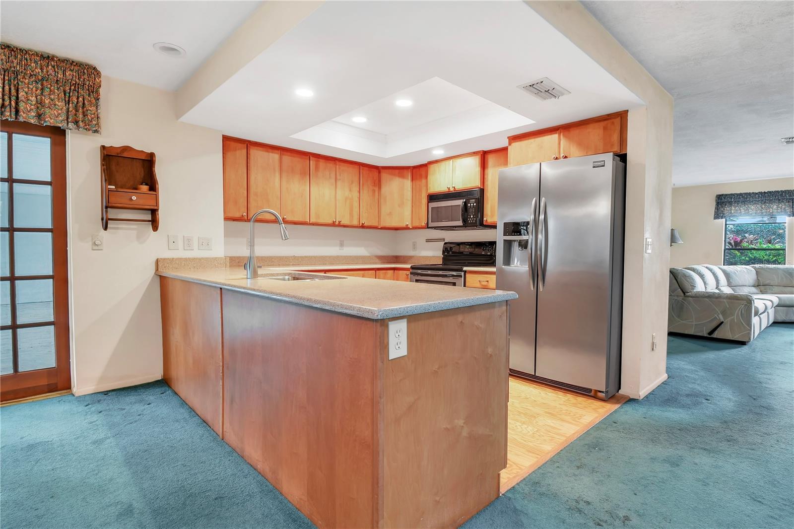 Updated kitchen for modern convenience, featuring Corian, SS and custom wood cabinetry.