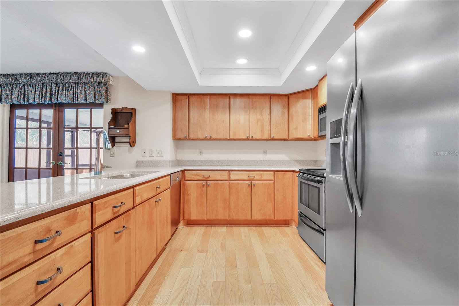 Updated kitchen for modern convenience, featuring Corian, SS and custom wood cabinetry.