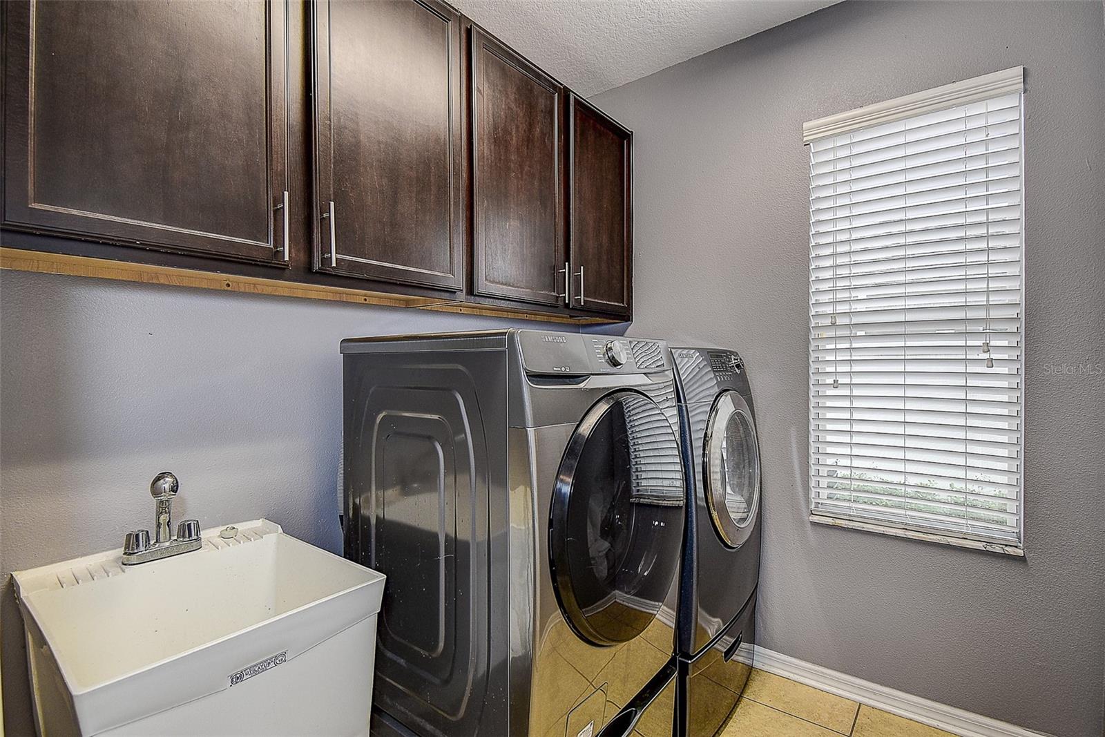 Laundry room with plenty of storage and utility sink