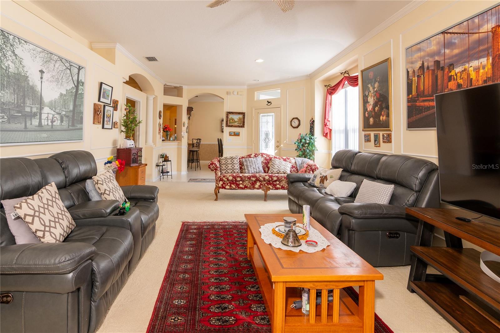 Living Room with crown molding and luxury carpet