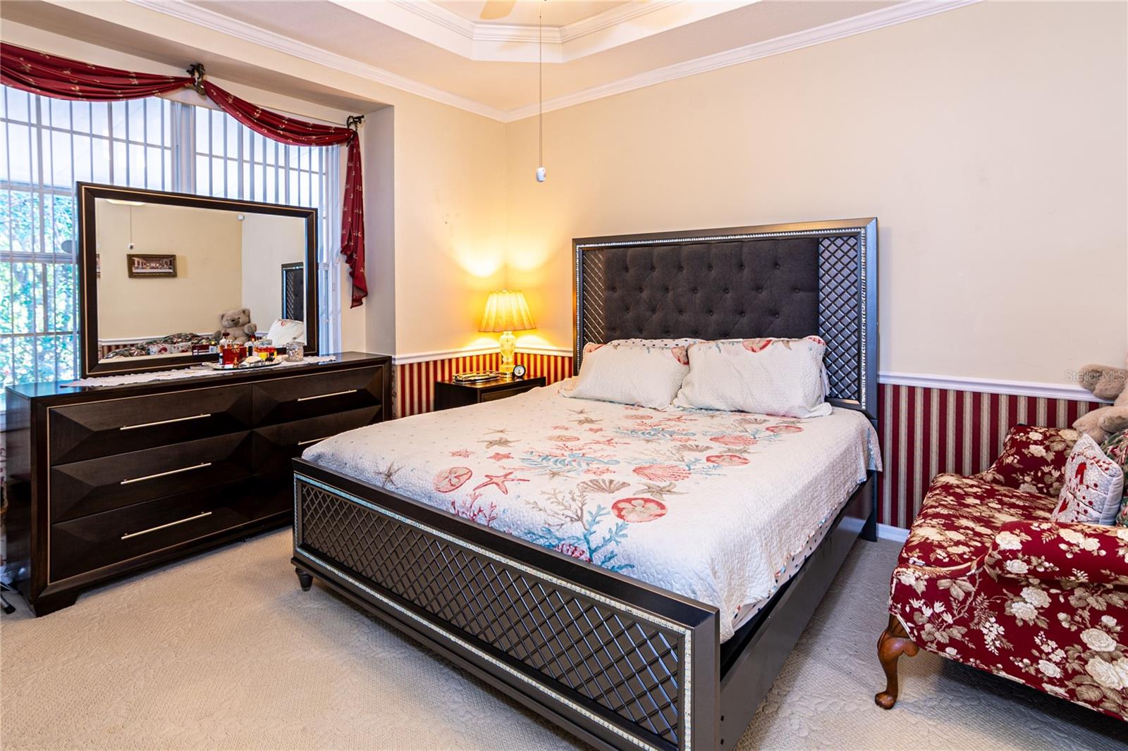 Large primary bedroom with tray ceilings and crown molding