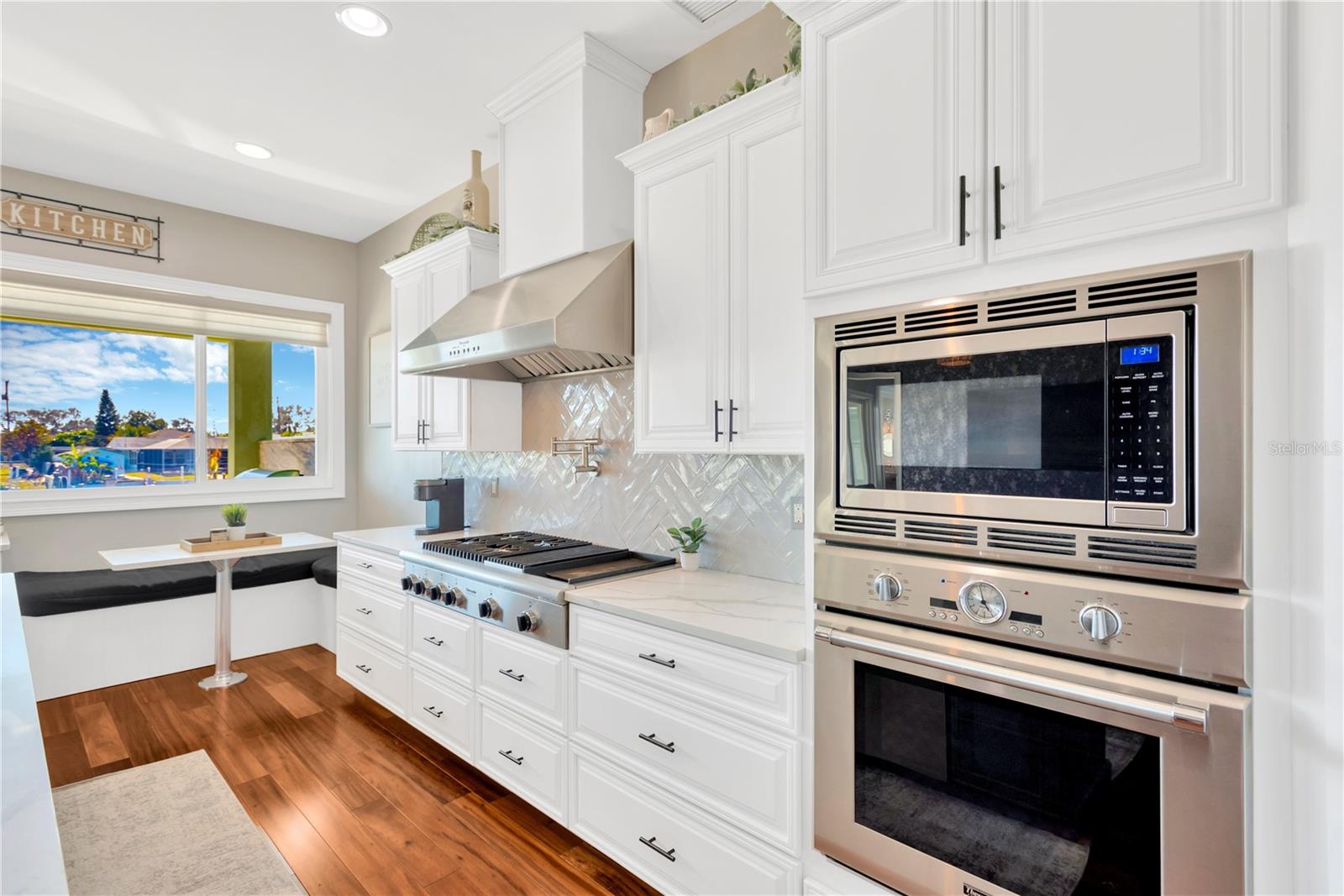 Kitchen View! Notice The Decorative Subway Tile Backsplash & The Cozy Banquette and Pass Through Slider Window Again!