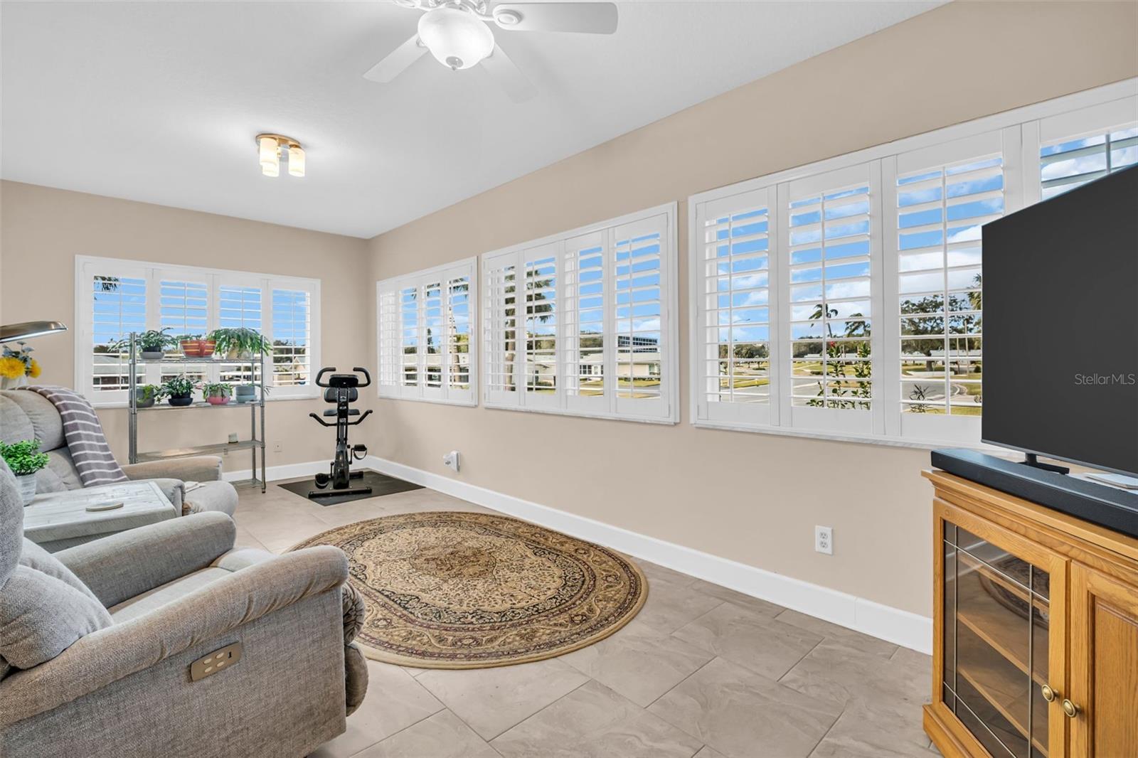 Andersen hurricane impact windows throughout the house are complemented by custom plantation shutters~