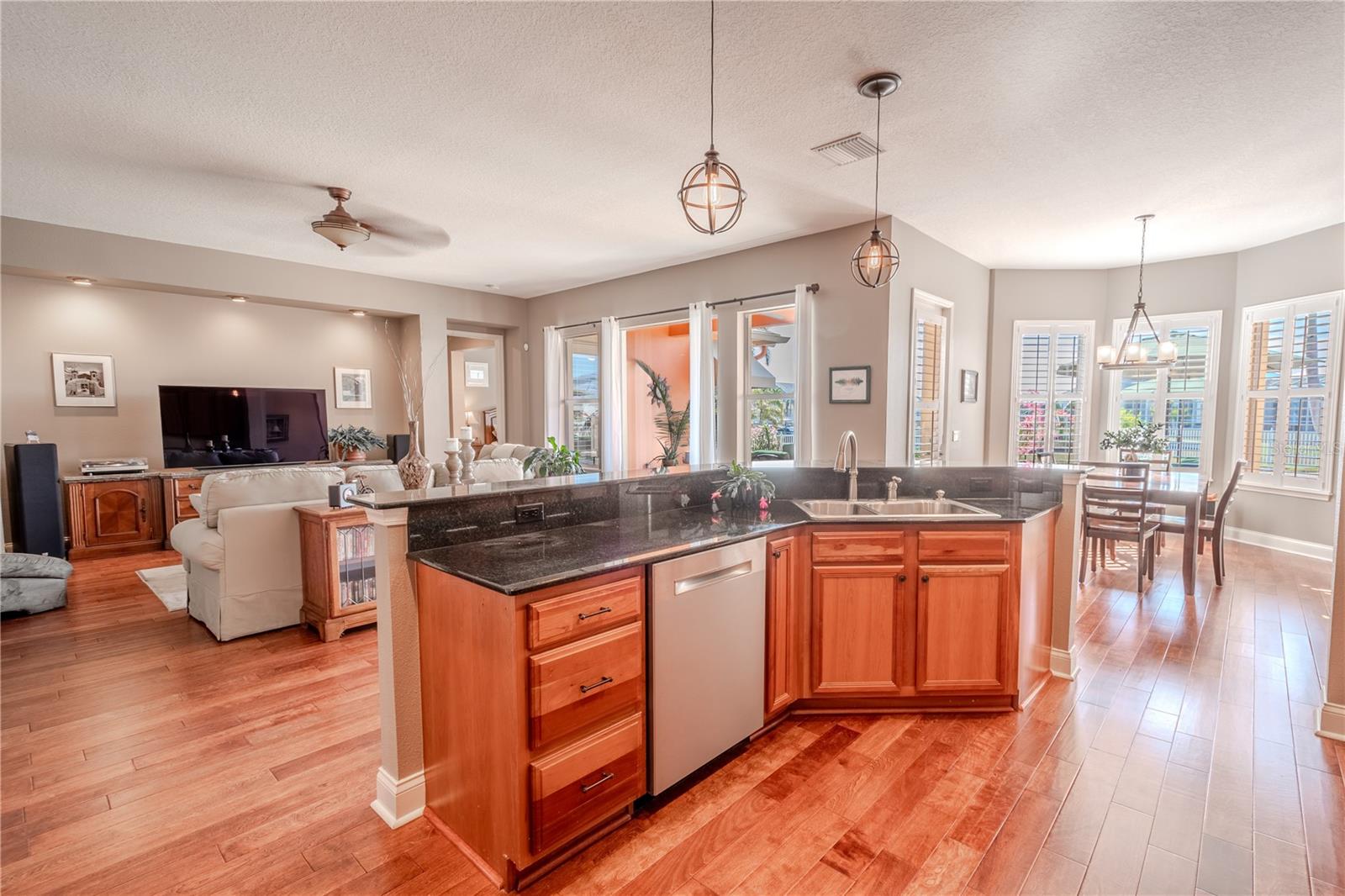 The kitchen island features a stainless steel sink and dishwasher, granite counters and additional drawers for storage.