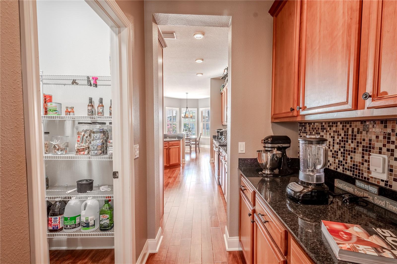 In between the dining room and kitchen is a butlers pantry and a walk-in pantry, maximizing space for stocking non-perishables, small appliances, and other kitchen essentials that don't fit in the cabinets.