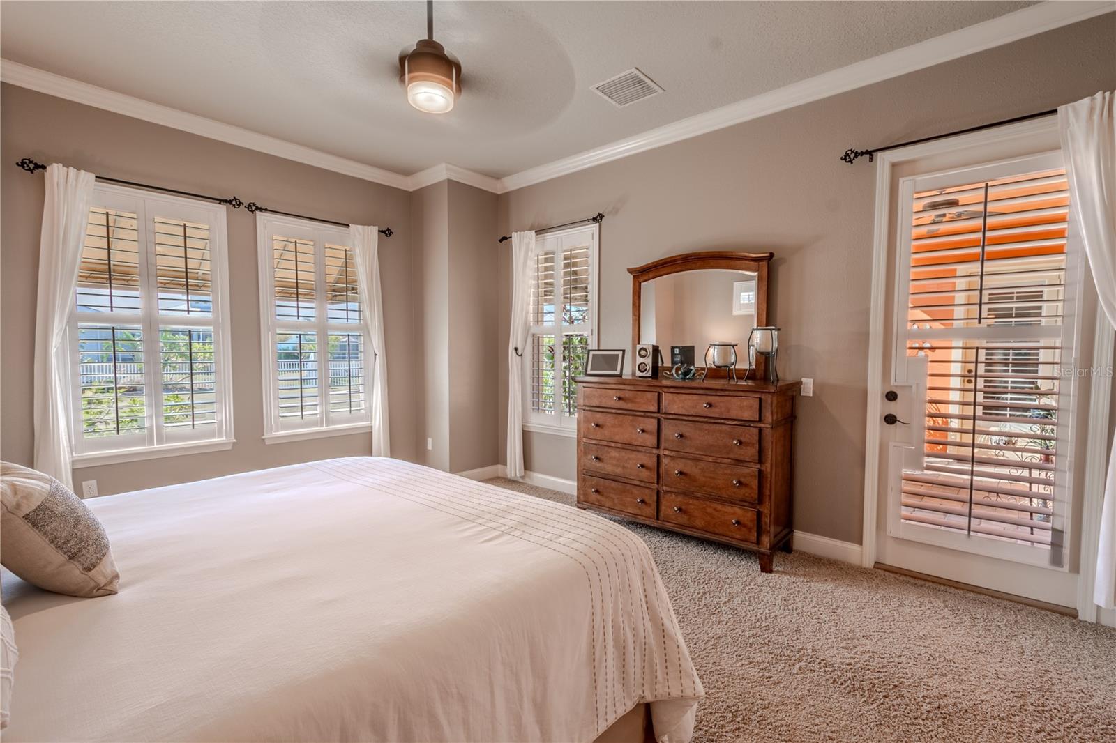 The primary bedroom has water views and a door leading to the covered rear patio.