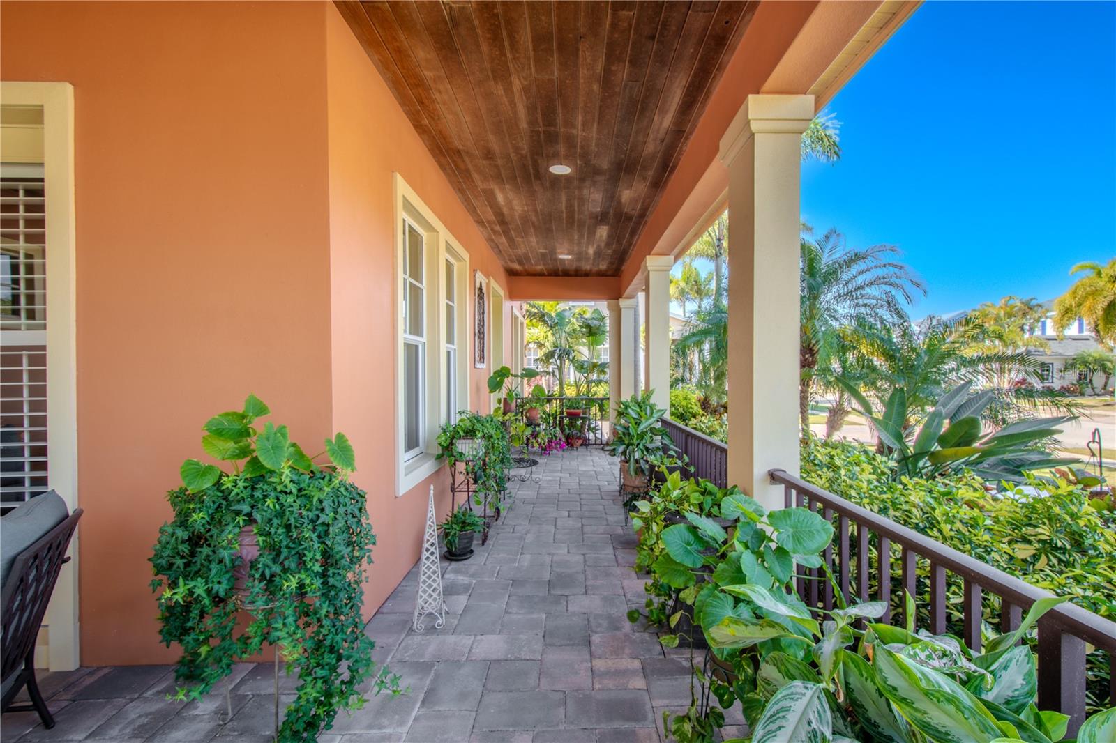 Covered wrap-around front porch (tongue and groove ceiling) with pavered floor and wrought iron railing.