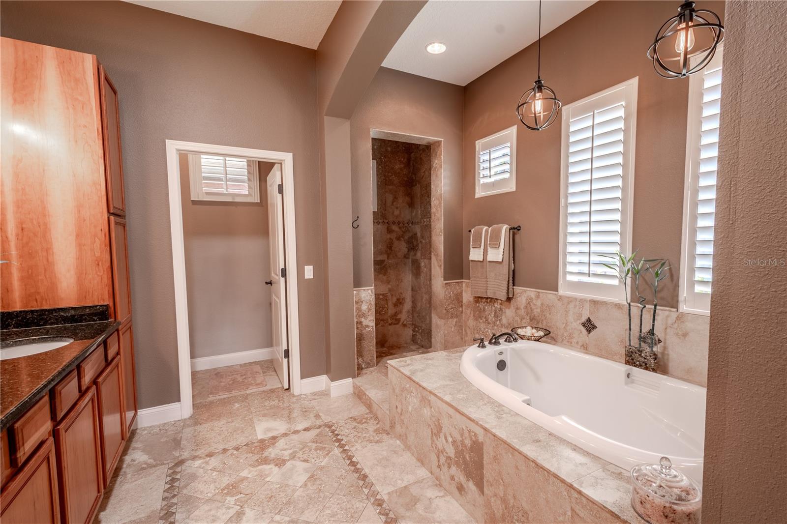 The primary ensuite bathroom features marble flooring, a soaking garden tub, and a seperate shower.