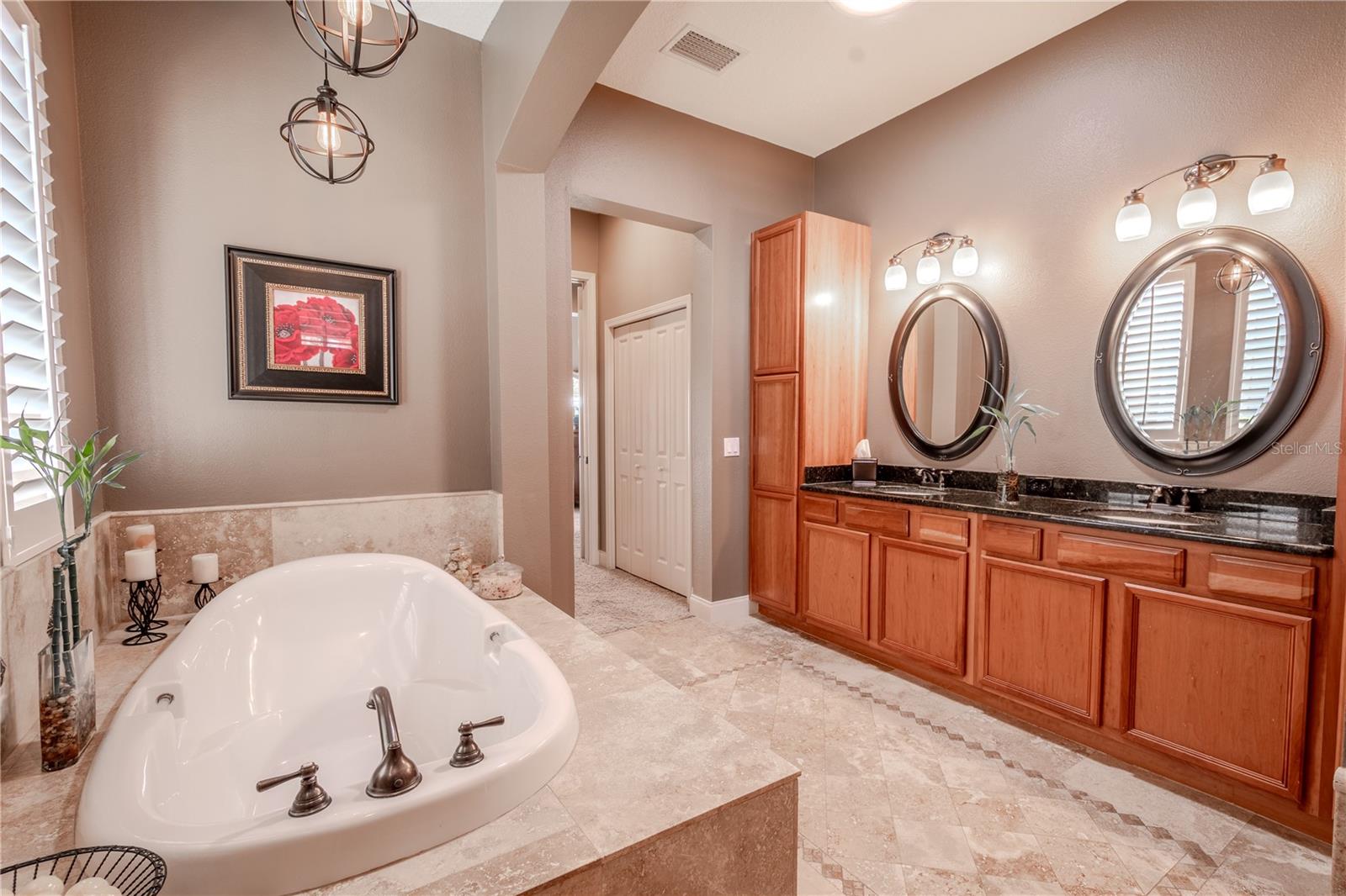 Two stylish pendant lights hang above the soaking tub.