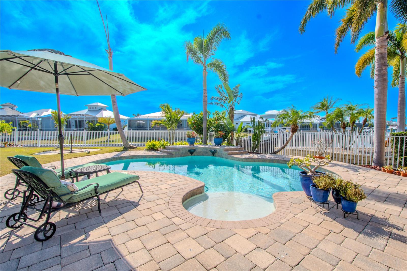 Heated pool with sun shelf  in a lush tropical setting