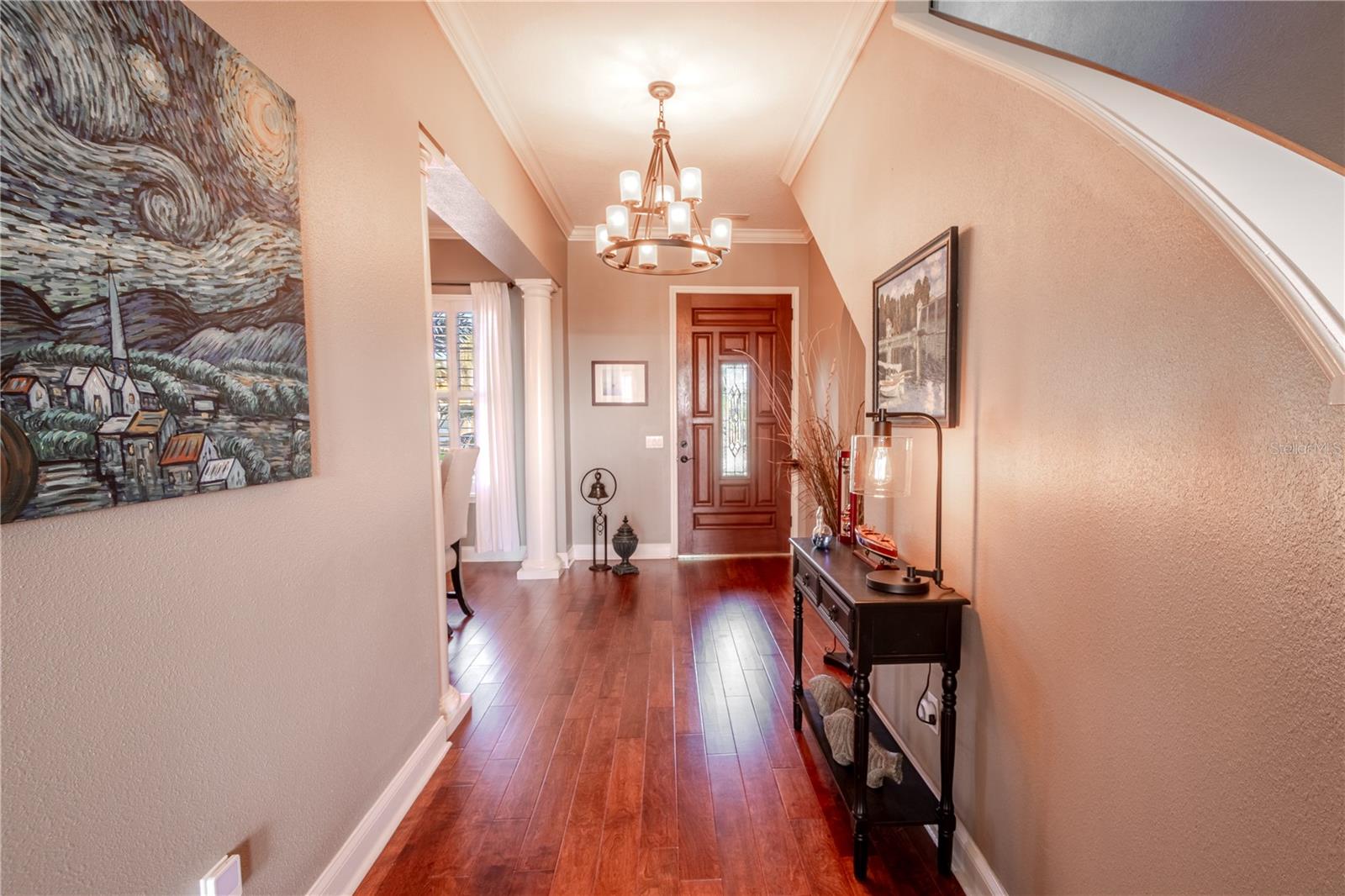 Welcome foyer with 9-globe chandelier, wood flooring and architectural details.