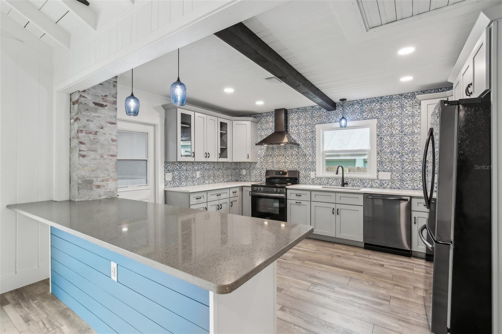 Your amazing gourmet kitchen with matching black stainless steel appliances and range hood.