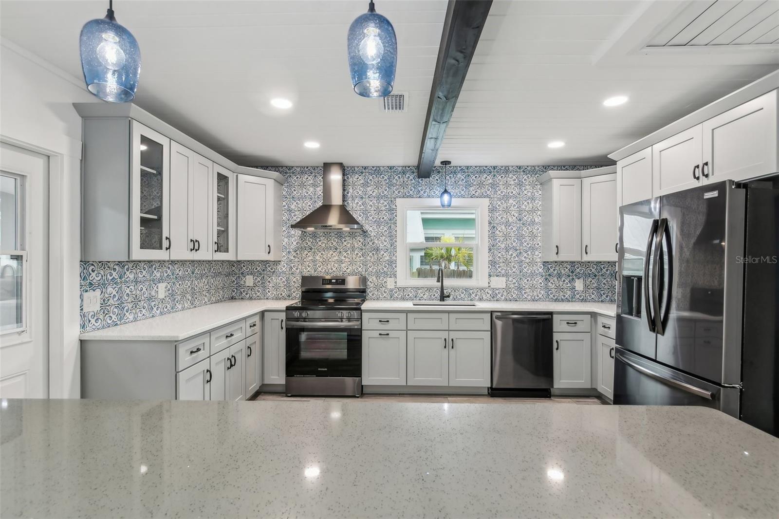 Your amazing gourmet kitchen with matching black stainless steel appliances and range hood.