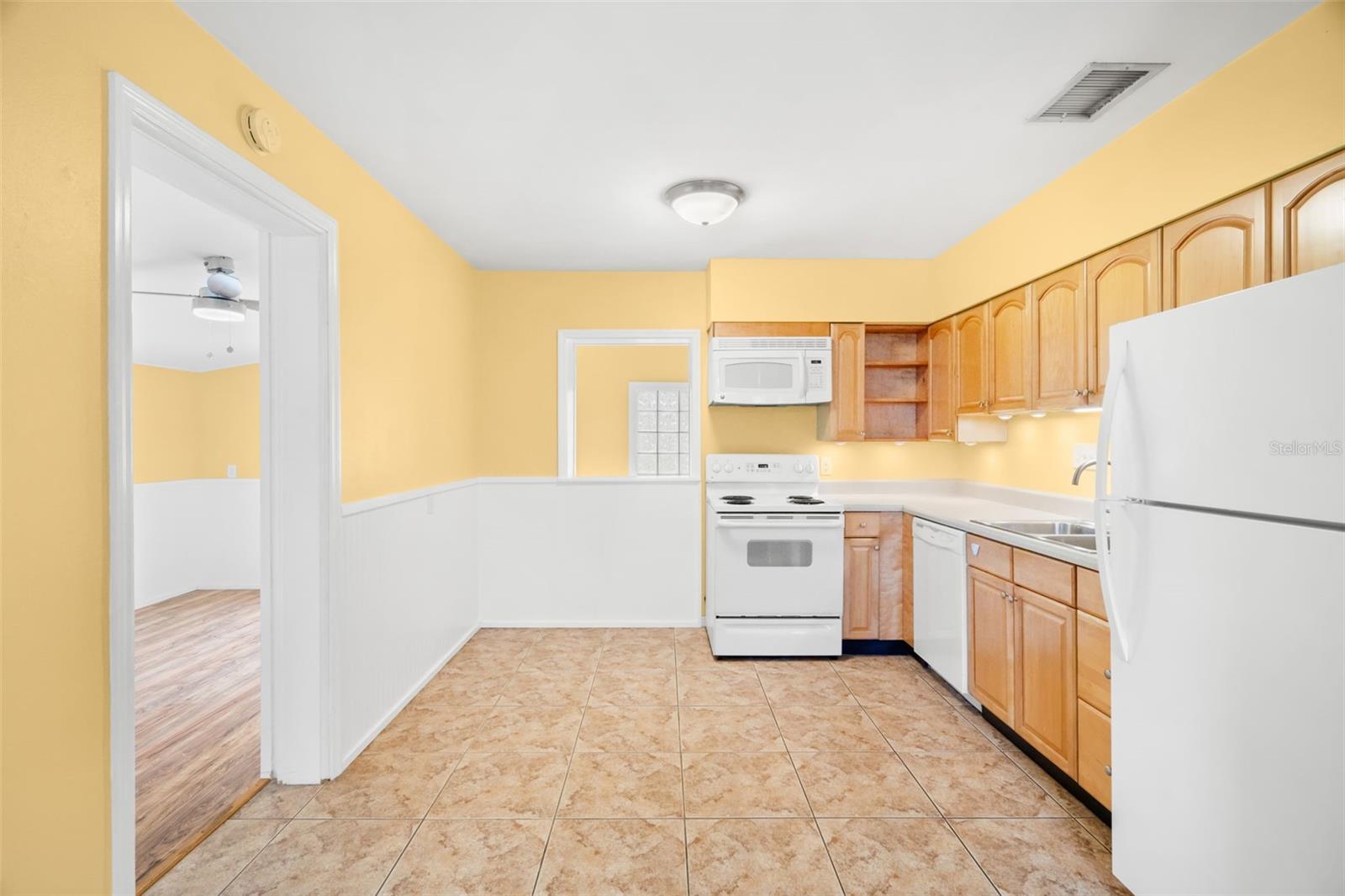 The thoughtfully designed eat-in kitchen features honey-toned wood cabinetry.