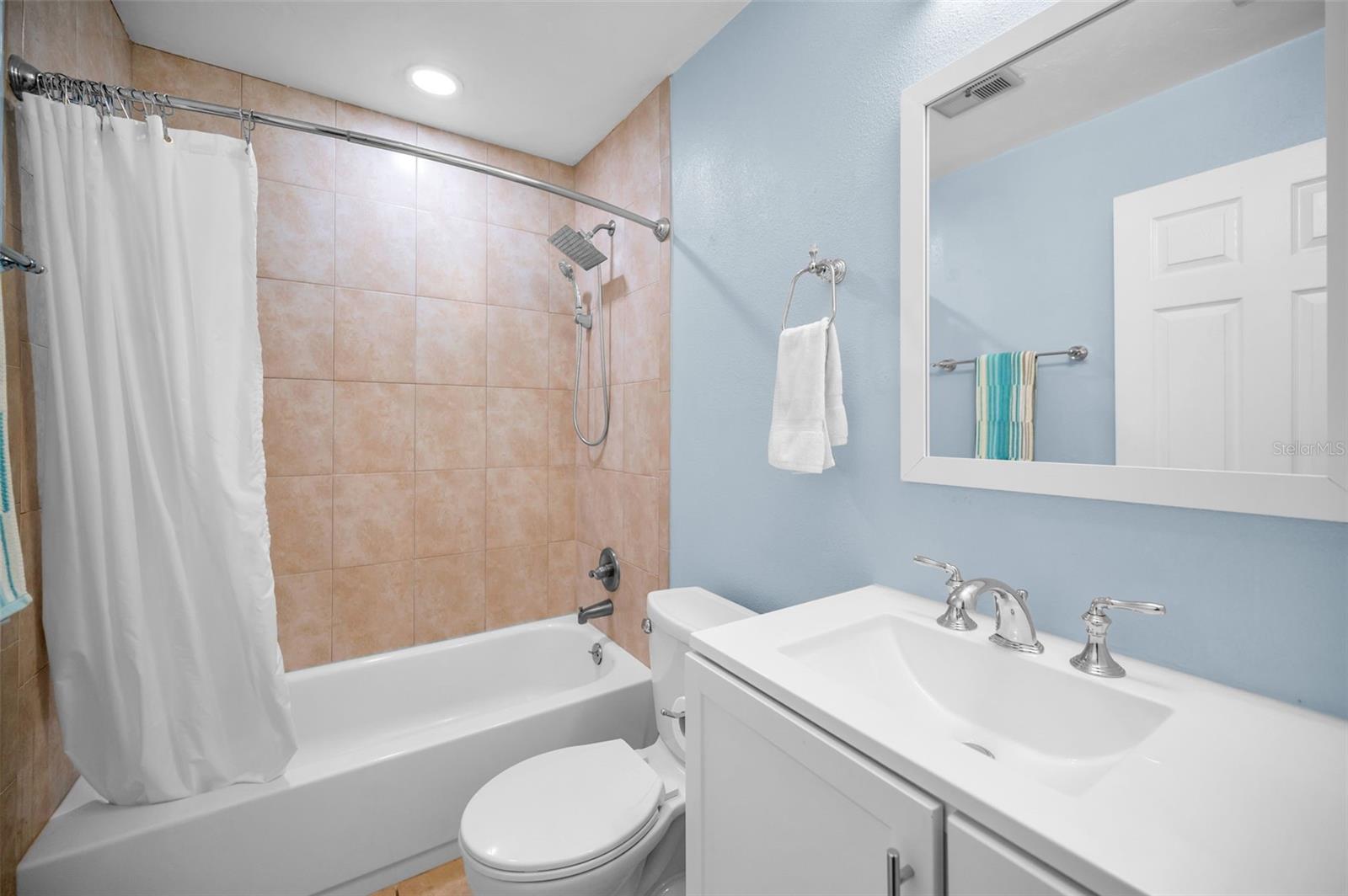 HALL BATHROOM WITH TILED WALLS AND TUB