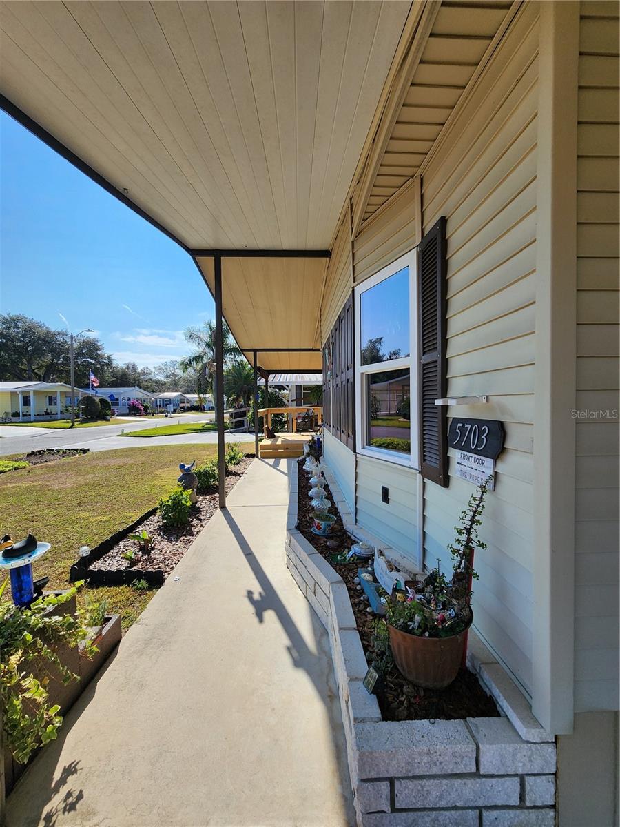 Wide front overhang with sidewalk & planter.