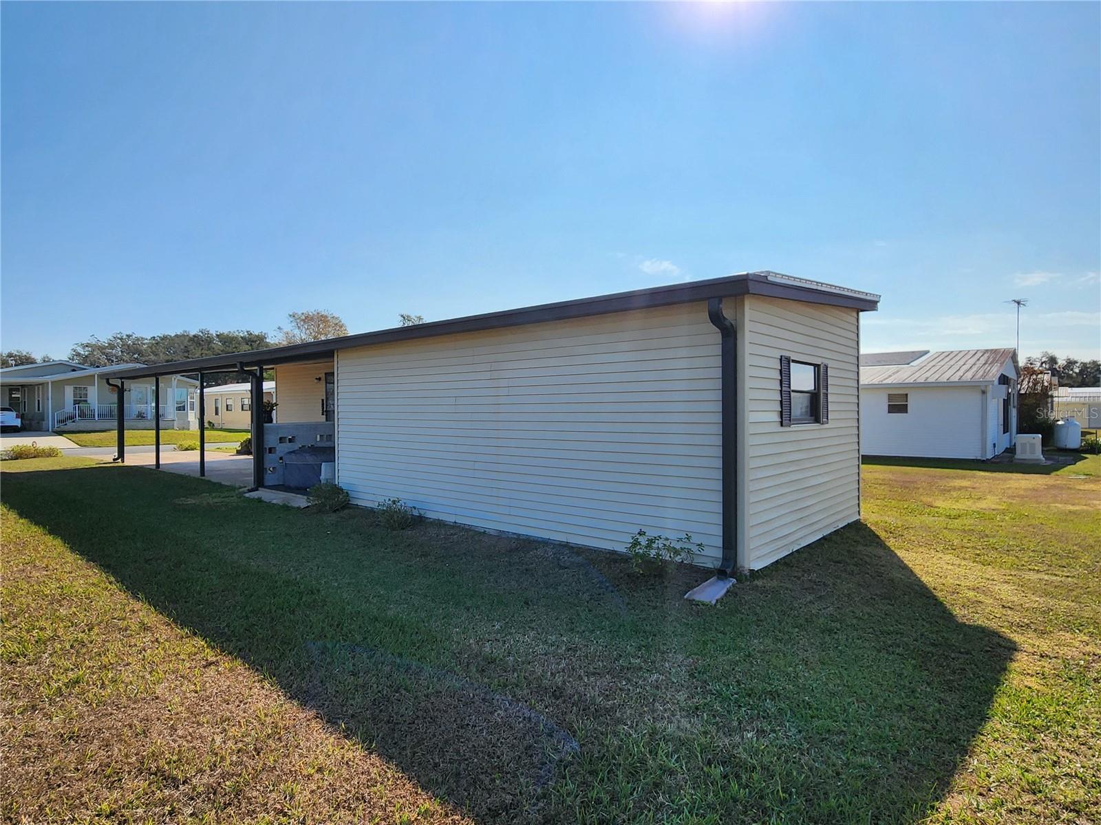 North side of home & add-on utility room with double door for golfcart parking.