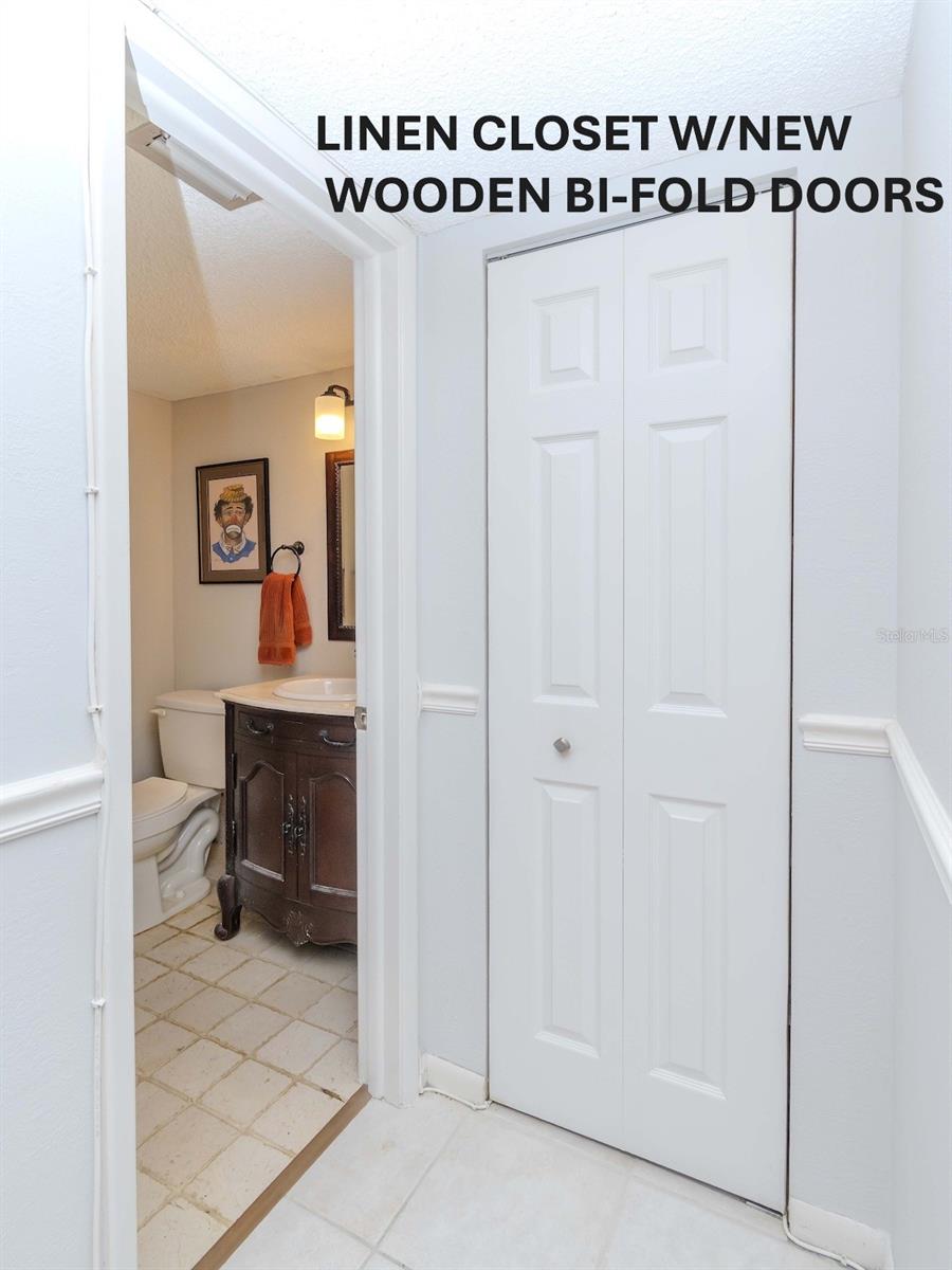 LINEN CLOSET WITH NEW BI-FOLD WOODEN DOORS