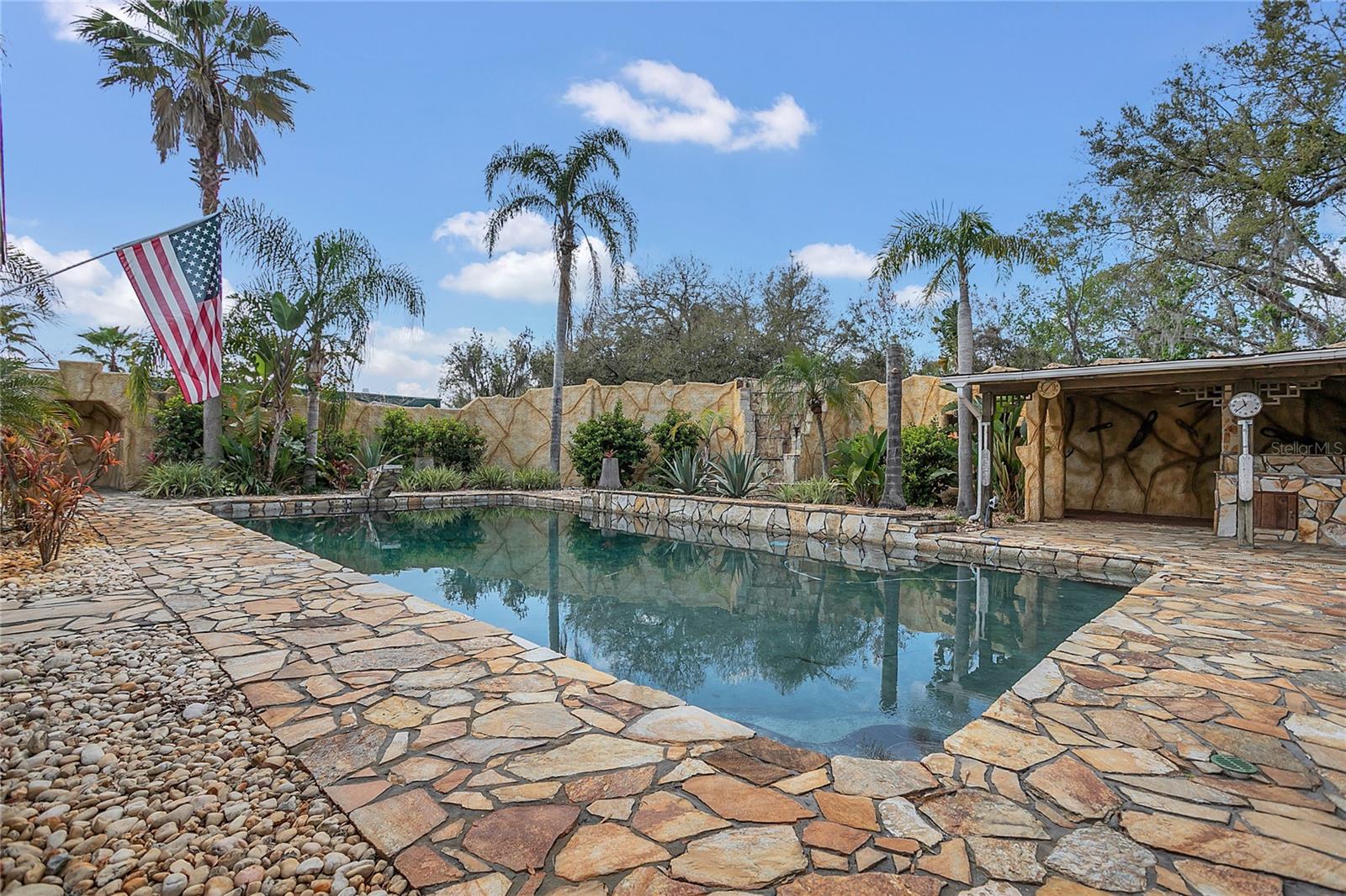 The grotto-style pool area is lushly landscaped