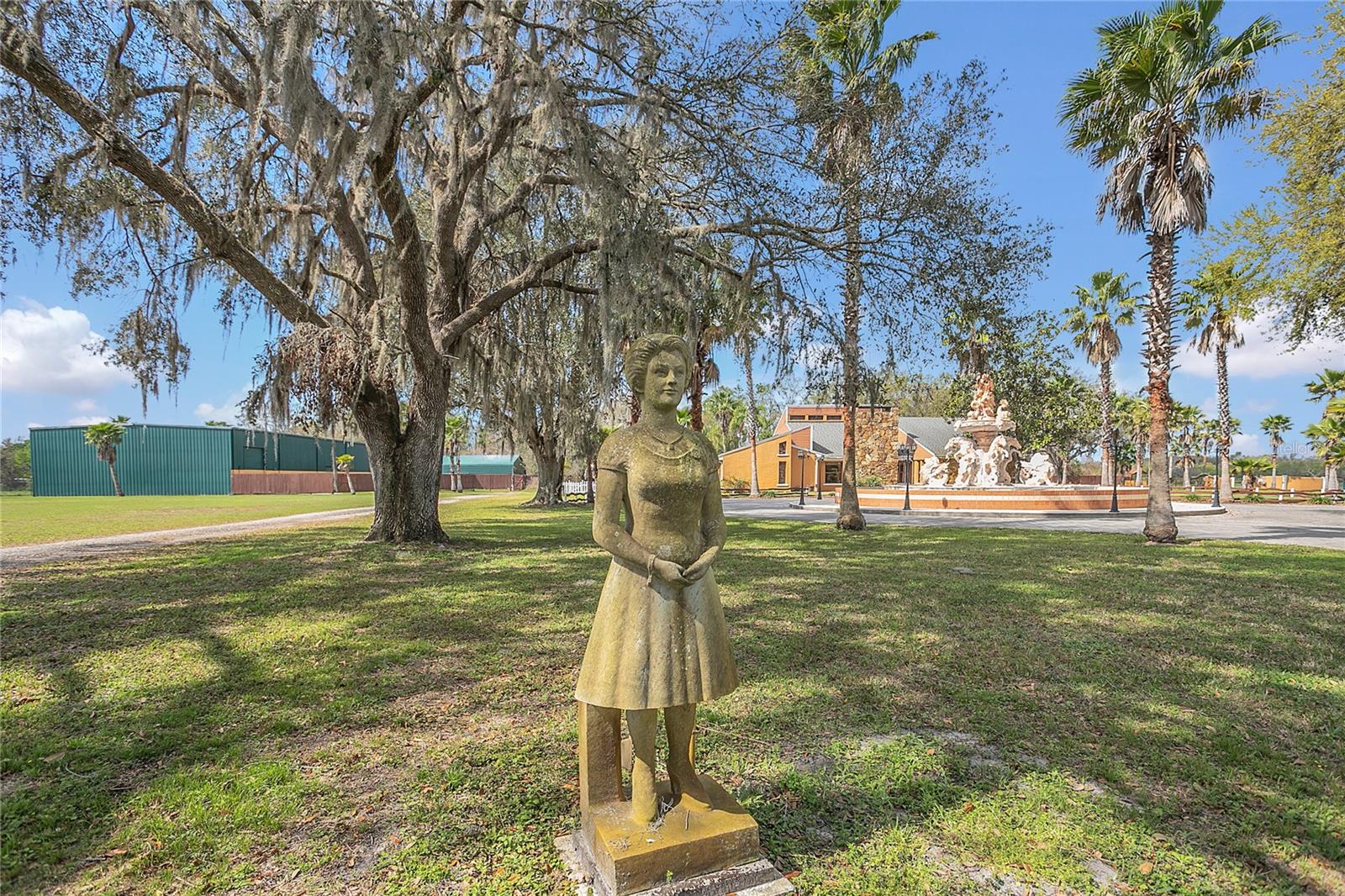 A statue of a lovely young maiden disguises a water faucet in the eastern yard