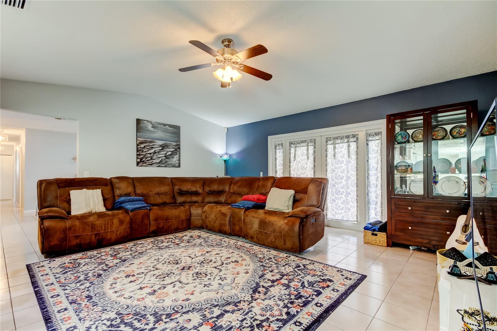 47. Family Room (18' x 17.2') Features Double French Doors w Side Lights w Tasteful Paneled Curtains - This is Your Doorway to the Lanai & Pool Area!