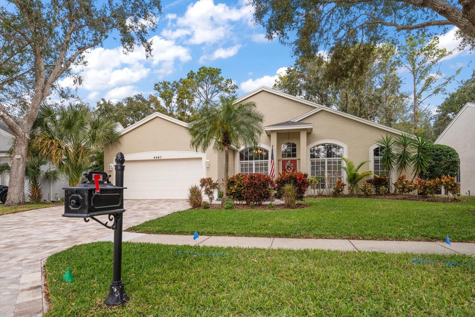 This is a picture of the front of the home. The paver driveway leads to a two-car garage.