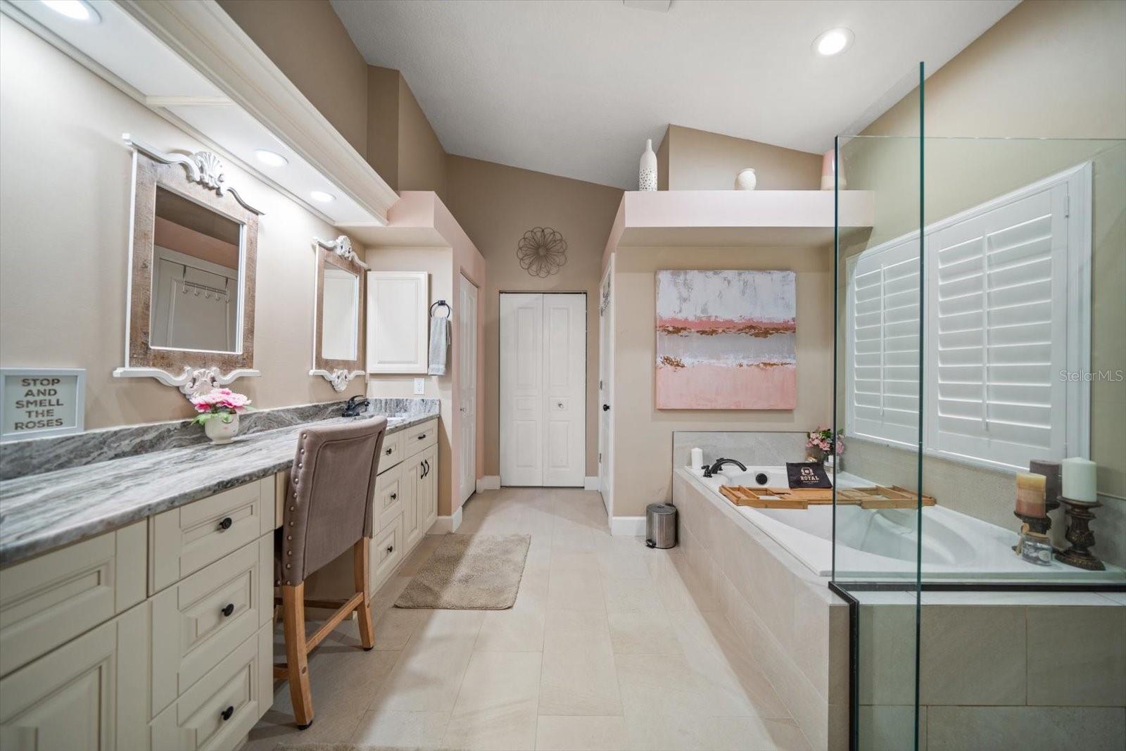 Primary en-suite bathroom with walk-in shower, soaking tub, double sink vanity, water closet and large walk-in closet