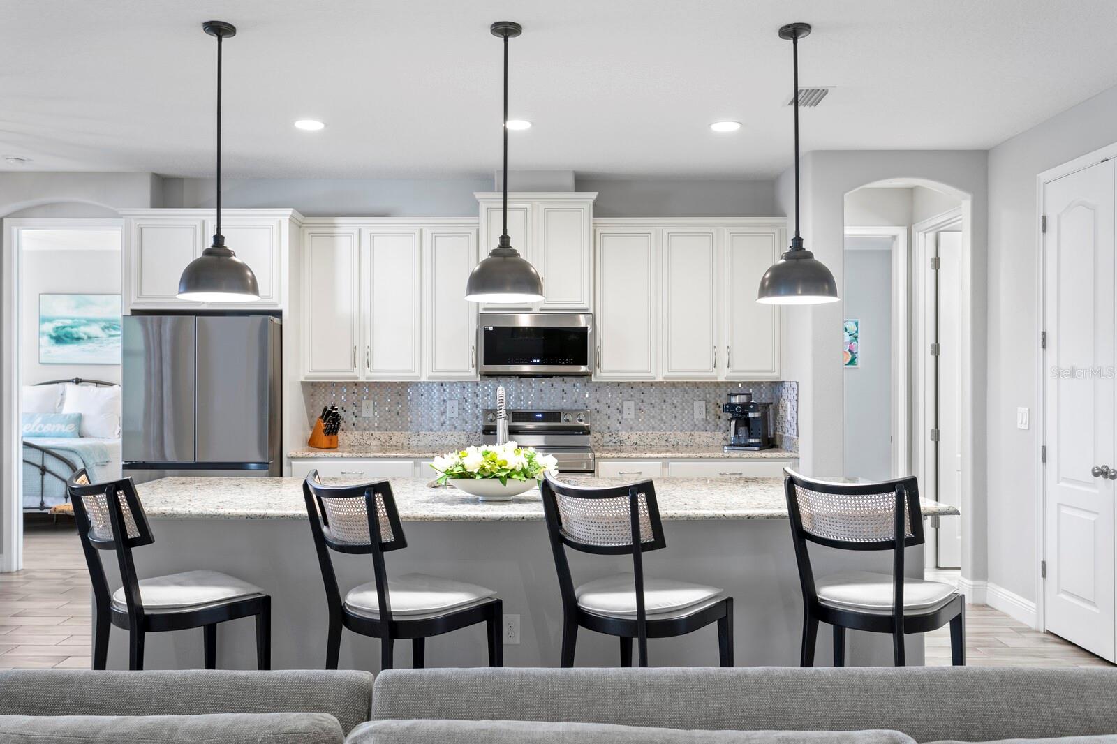 The kitchen features a large center island and pendant lighting