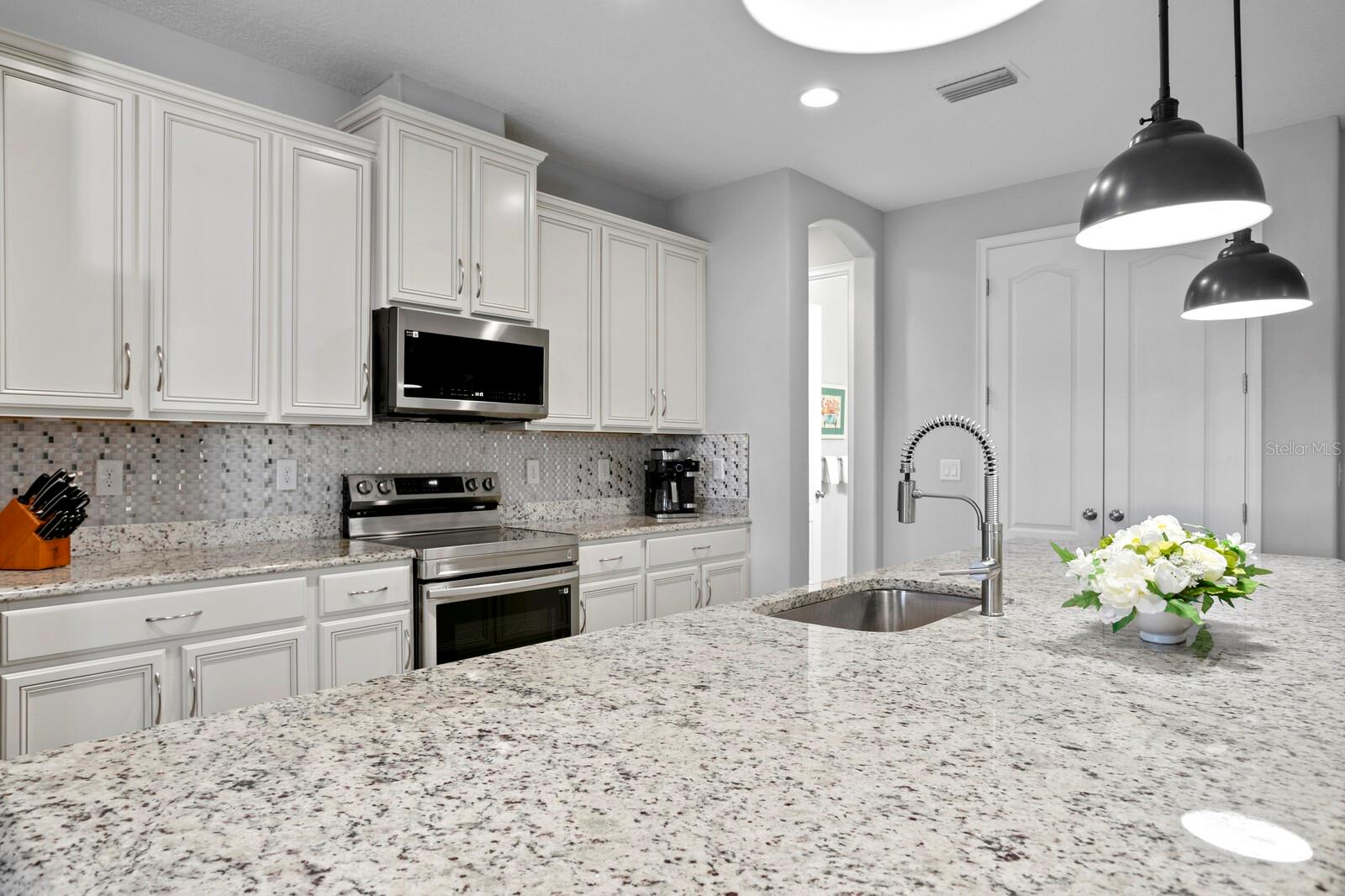 The kitchen includes a gorgeous glass tile backsplash