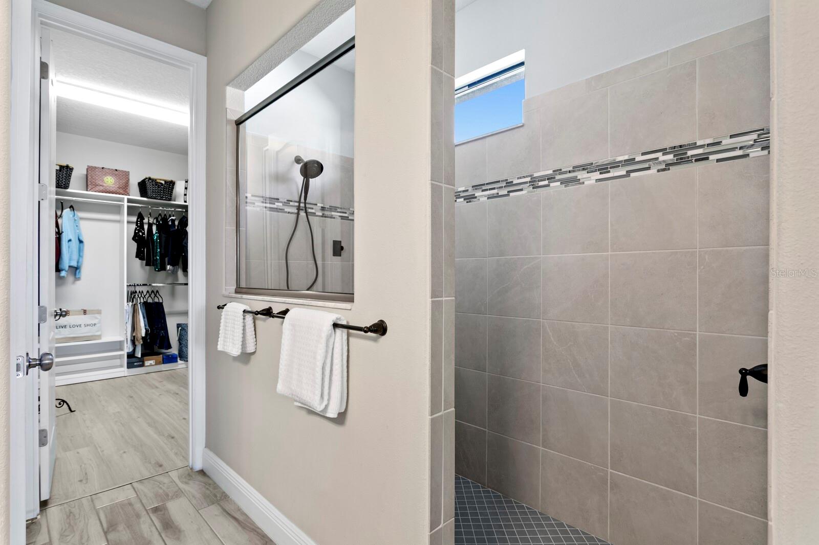 The oversized walk-in shower in the primary bath includes a rain shower head