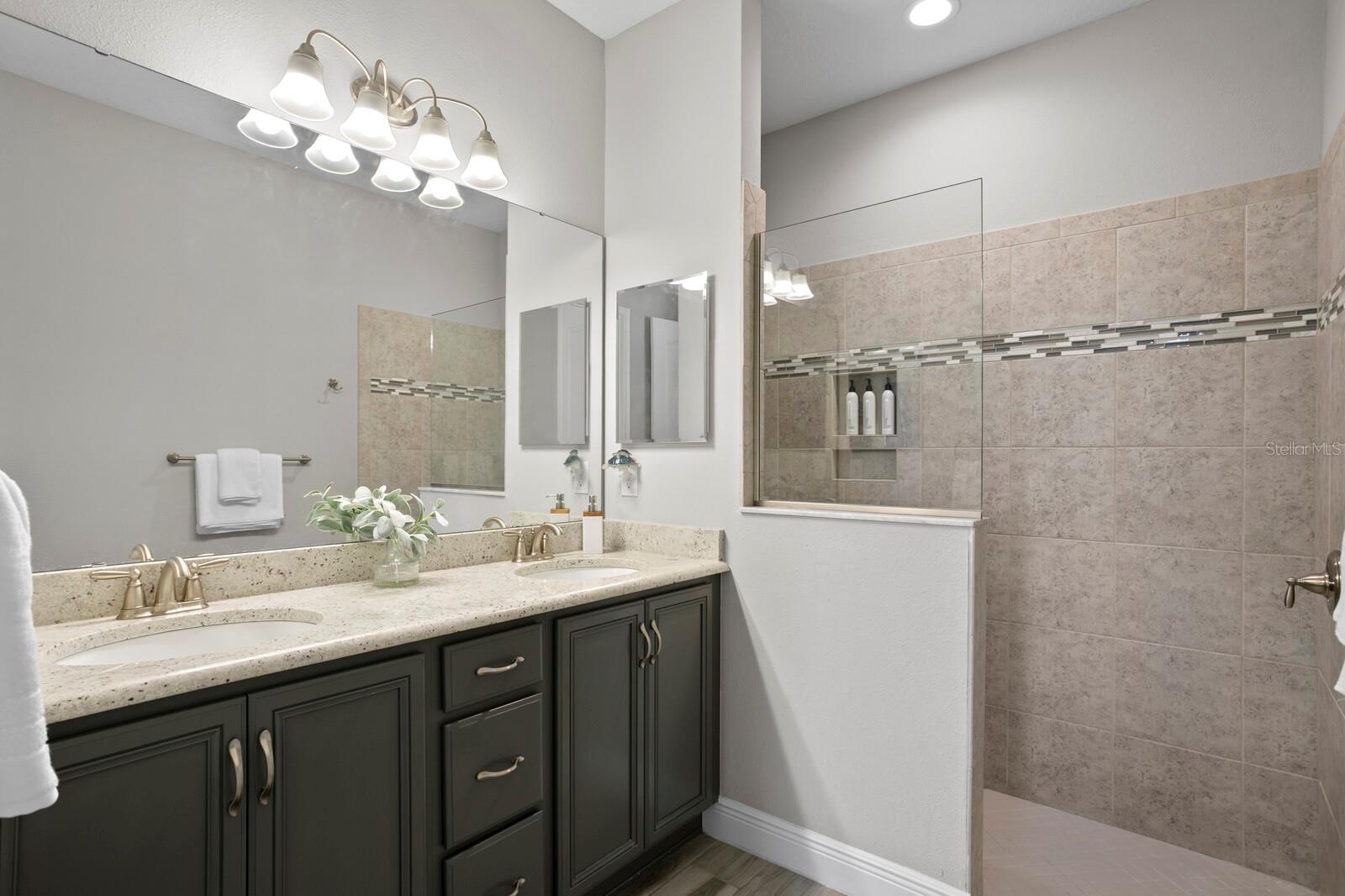 The 2nd master suite includes an upgraded vanity and walk-in-shower with a rain shower head