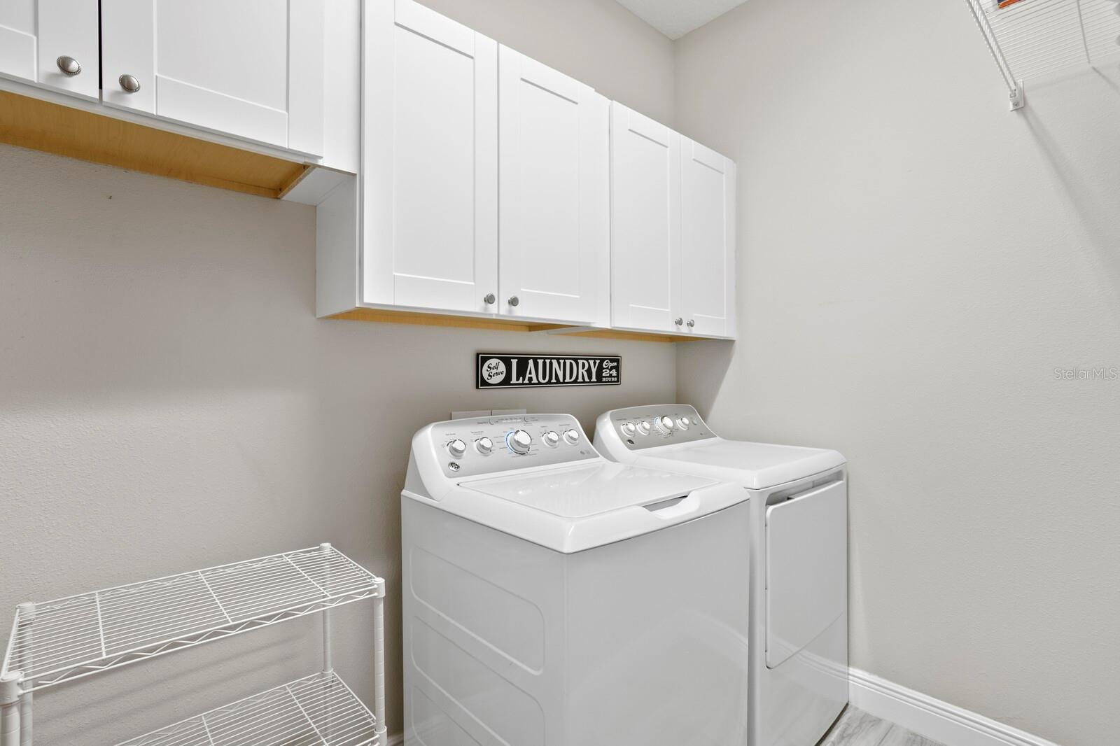 The spacious laundry room includes addtional cabinet storage