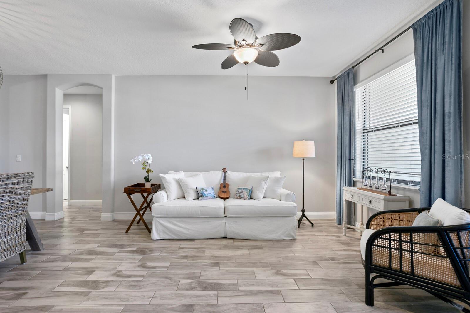 In the formal liing room you'll find great natural light and a ceiling fan