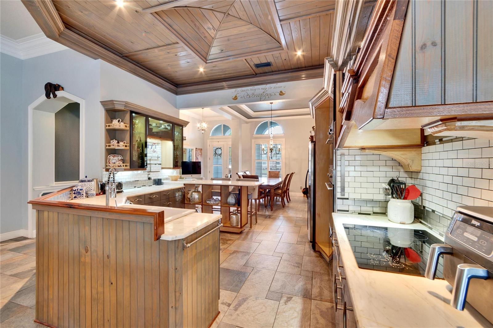 CUSTOM KITCHEN WITH STAINLESS STEEL APPLIANCES, MARBLE COUNTERTOPS AND TILED BACKSPLASH