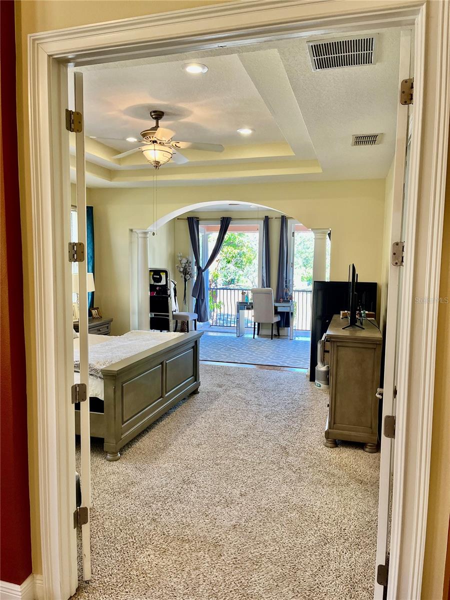 View into the primary bedroom suite through the 8ft double doors all the way through the French door onto the 1st balcony