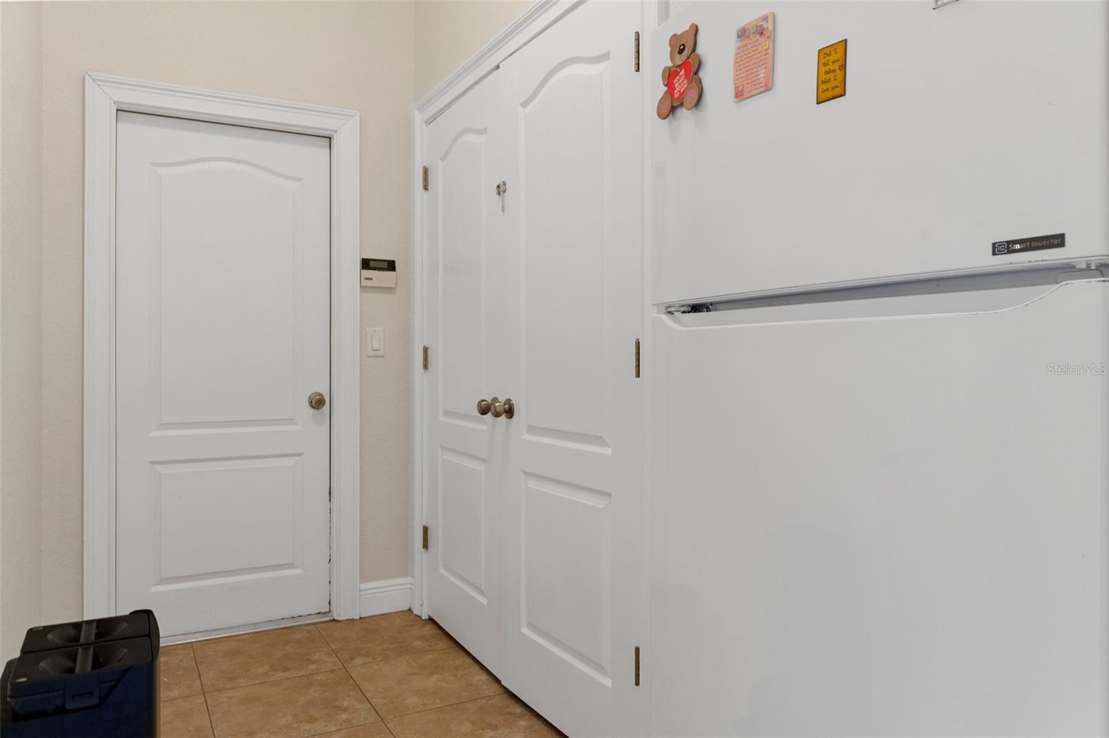 Utility mud room with storage closed and room for a freezer or extra refrigerator.