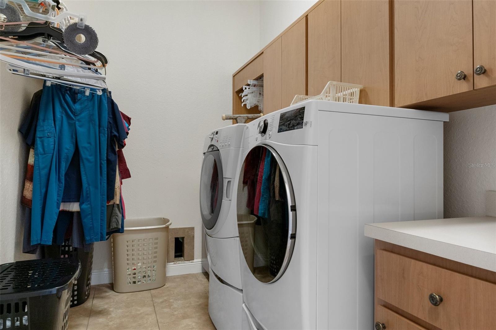 Utility/Mud Room with cabinets and storage closet