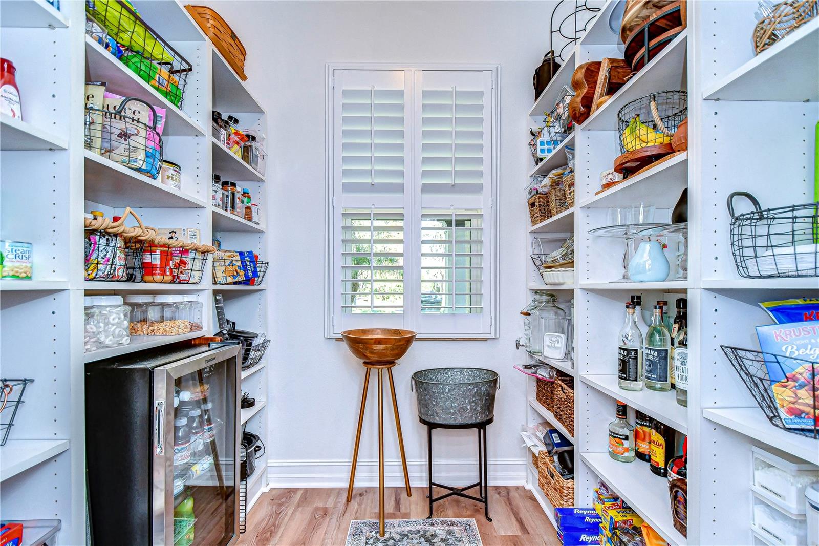 HUGE walk in pantry featuring built ins and space for a small drink refrigerator.