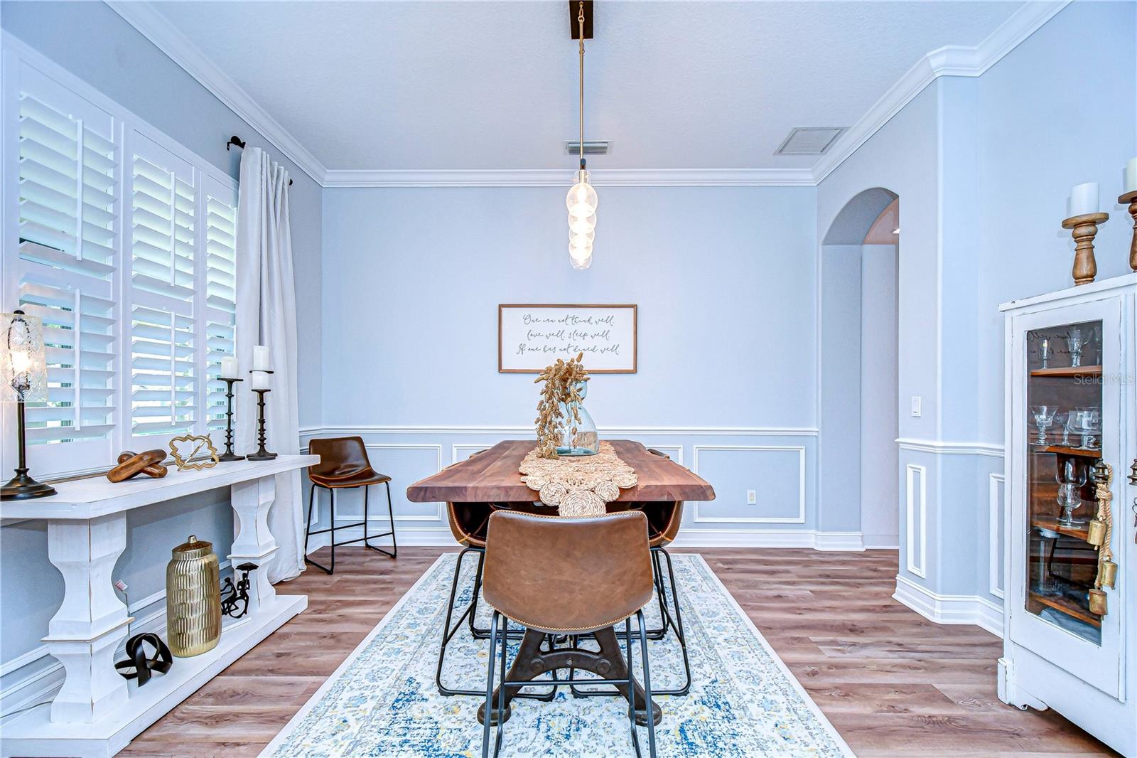 Spacious dining room features plantations shutters and thoughtfully curated molding.