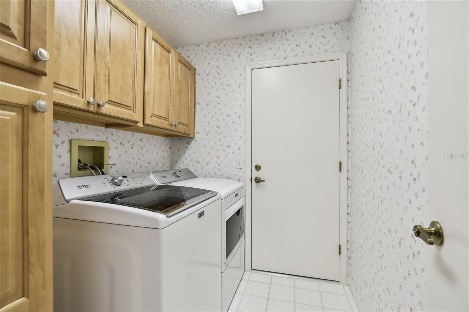 Laundry room off kitchen and garage, all tiled. Drop your clothes off after a day of golfing