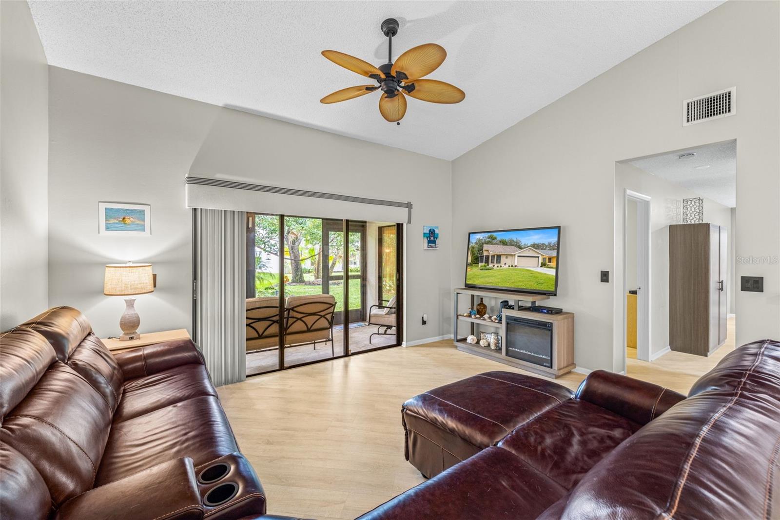 View of Living Room! Plenty of room for that ex-large flat screen TV!. The living room has high ceilings, and sliding glass doors to the screened in lanai.