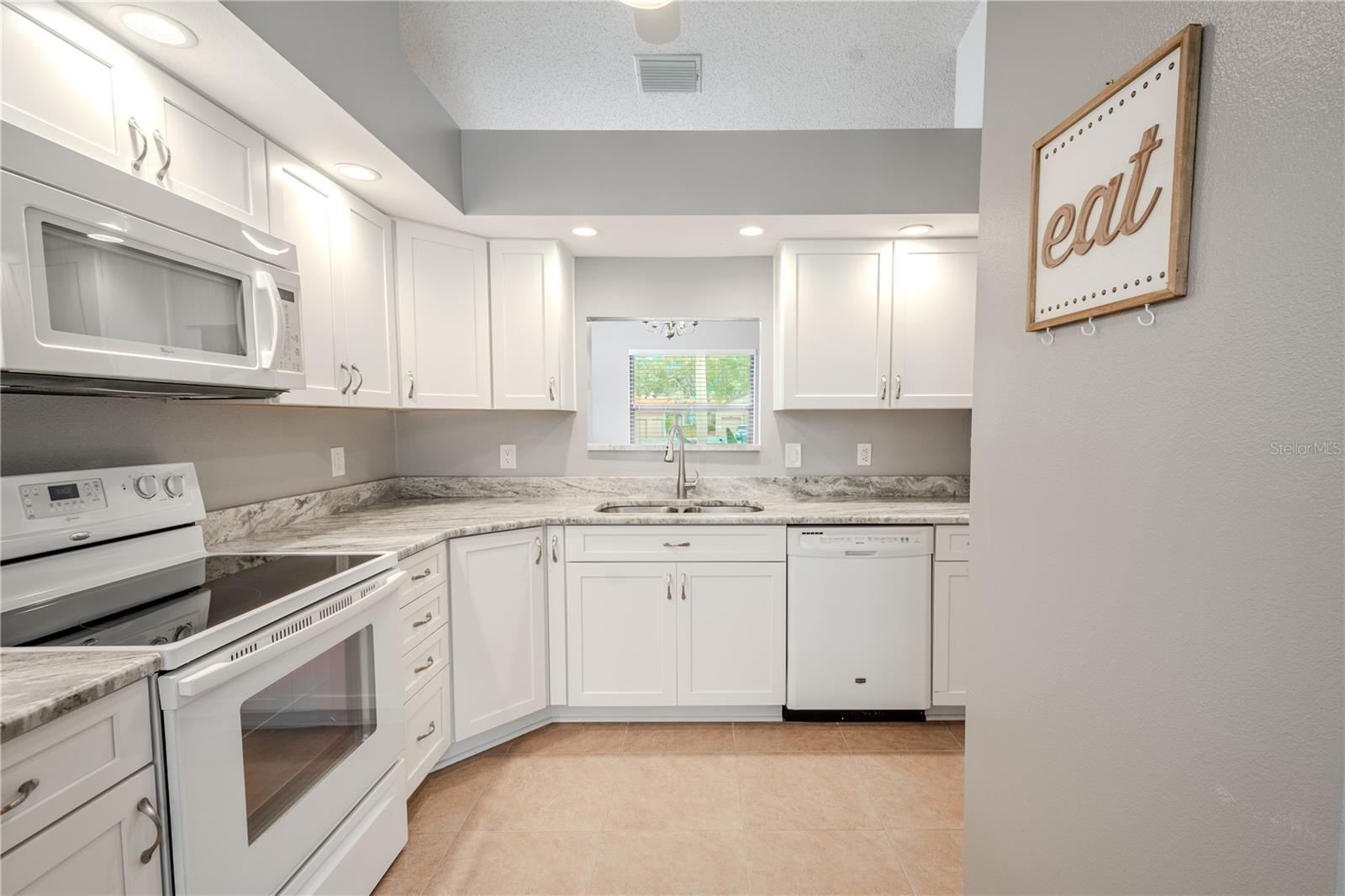 The kitchen features recessed lighting adding to the kitchen's ambiance