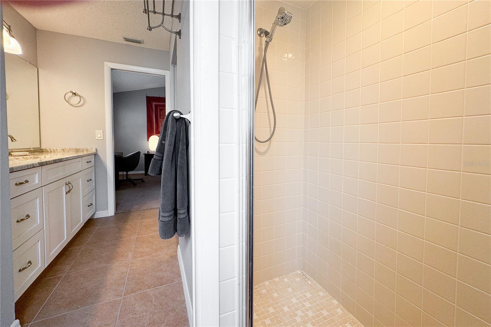 The primary bathroom features ceramic tile flooring and a step-in shower.