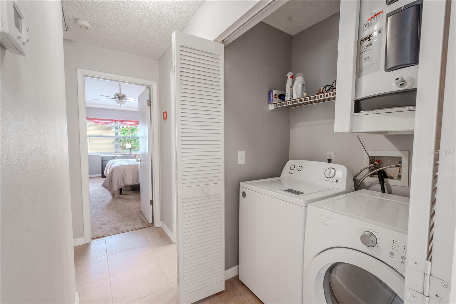 The home features and laundry closet with washer, dryer and overhead shelving.