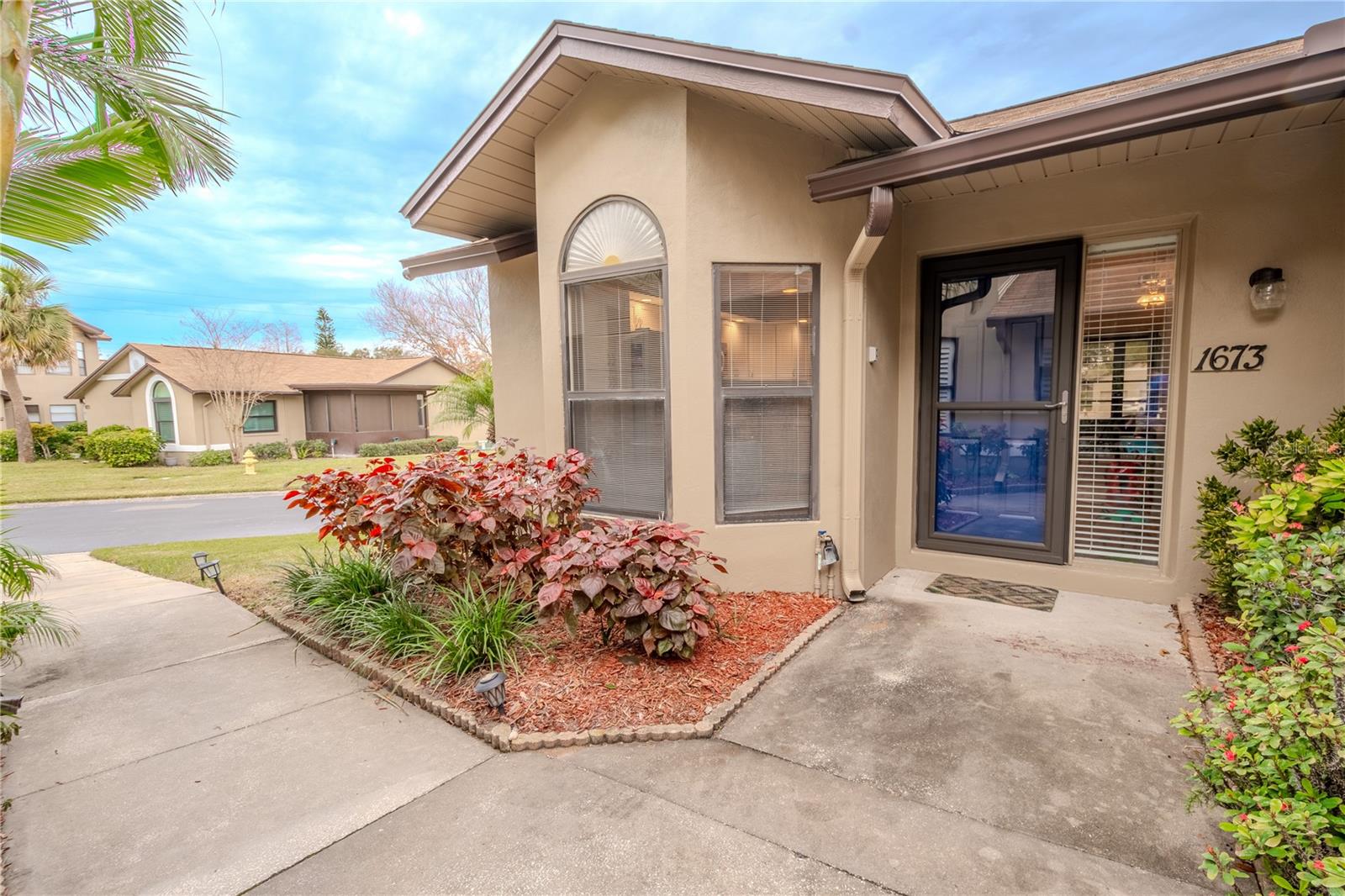 Lushly landscaped, covered front entrance