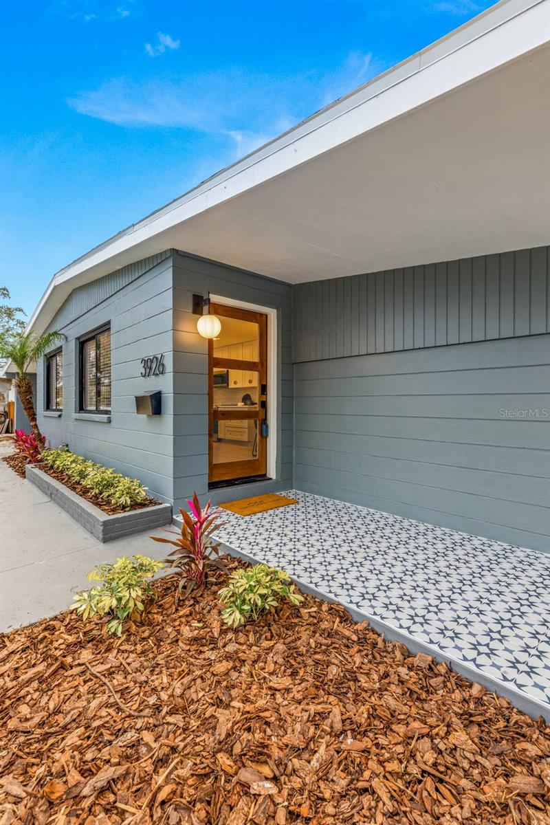 Front entryway with mosaic tile and modern glass door